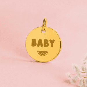 Médaille en or avec inscription BABY et dessin de tranche de citron.