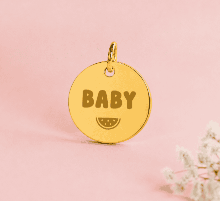 Médaille en or avec inscription BABY et dessin de tranche de citron.